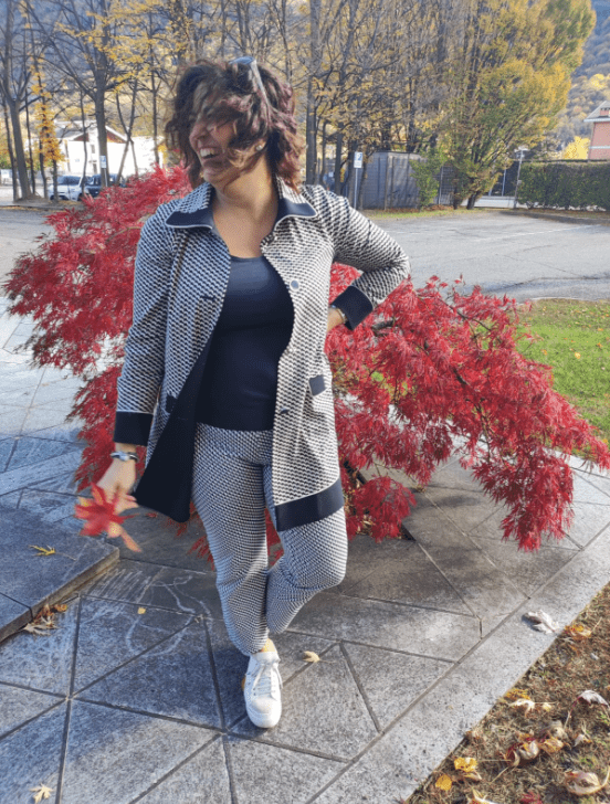 Foto di Raffaela Marescalco davanti ad una pianta dalle foglie rossastre. Le sue consulenze feng shui professionale ti cambieranno la vita