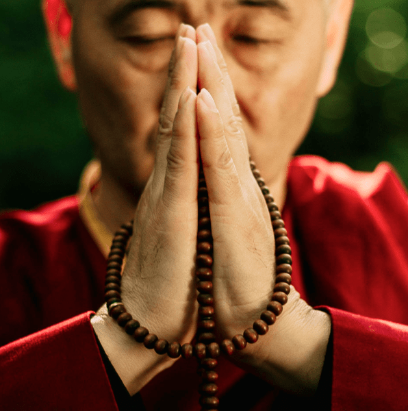 Uomo orientale esperto di Ba Zi in preghiera con tunica rossa.