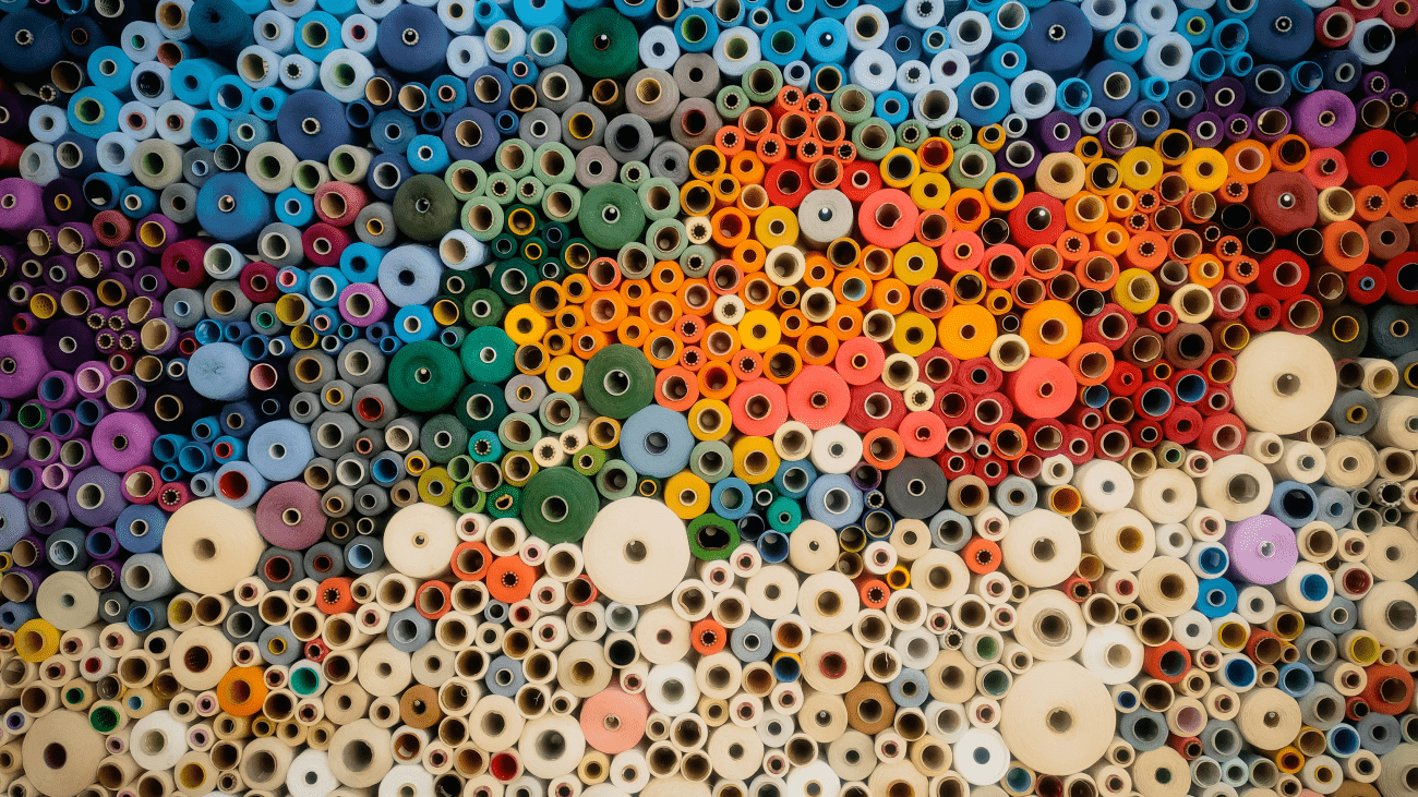 Armocromia. Tanti tessuti di diversi colori su dei rotoli accuratamente ordinati