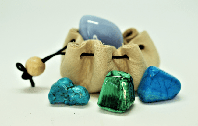 Zoom su un sacchetto in pelle giallo chiara con cristalli dai colori freddi