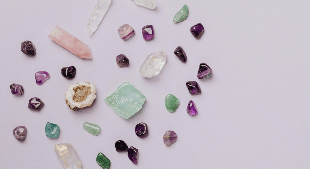 cristalli di diverse forme e colori poggiati su una superfice violetta