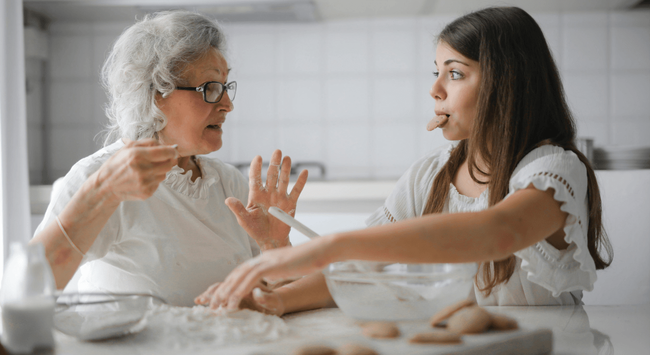 Come stare bene a casa. Una ragazzina e sua nonna si divertono mentre cucinano assieme dei biscotti