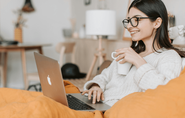Come stare bene a casa. Una ragazza lavora serenamente al pc mentre sorseggia un tè