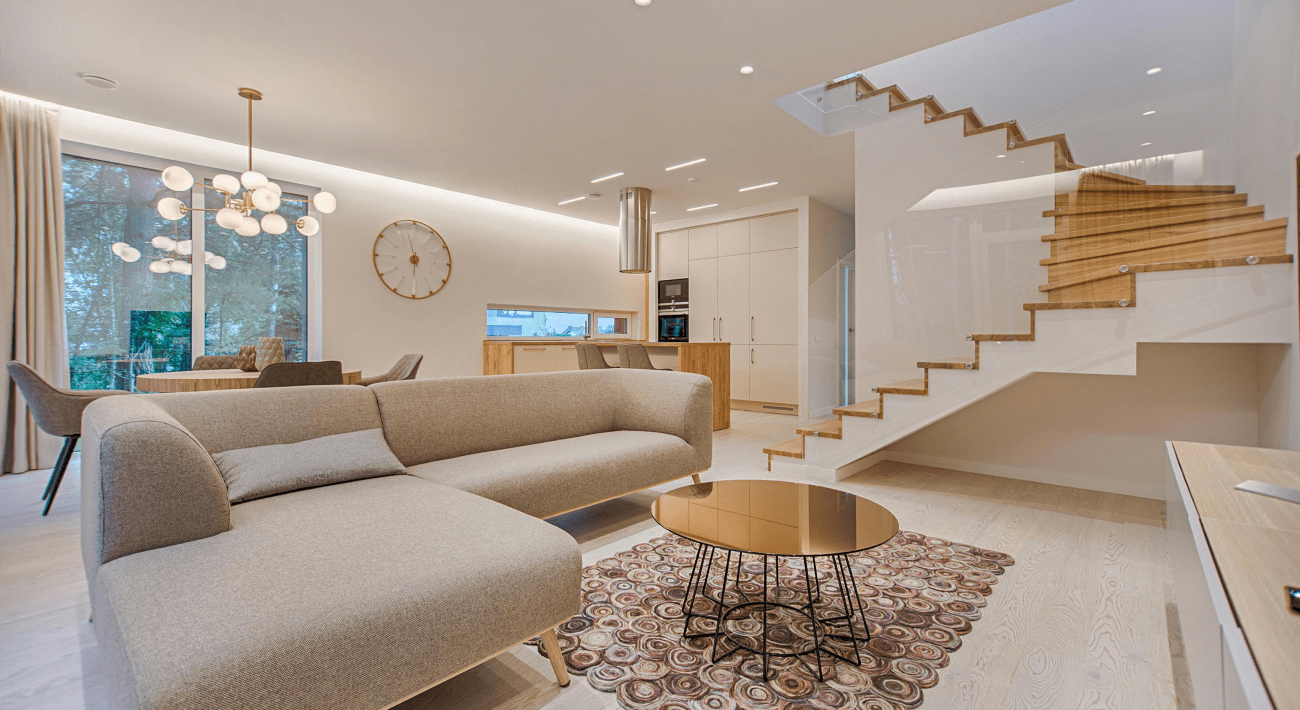 Home Staging. Luminoso soggiorno con divano color tortora ad angolo e davanti un tavolino color bronzo.