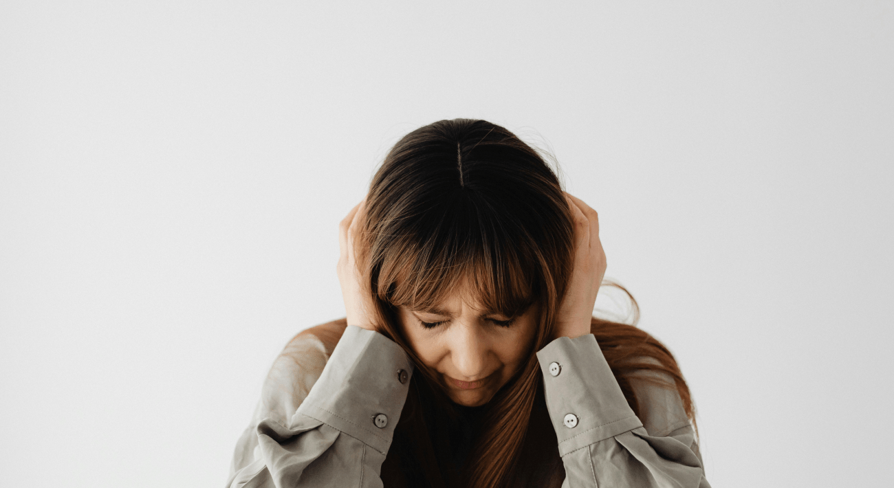 Una donna si copre le orecchie in preda al dolore interiore